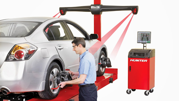 A graphic depicting a mechanic carrying out a wheel alignment